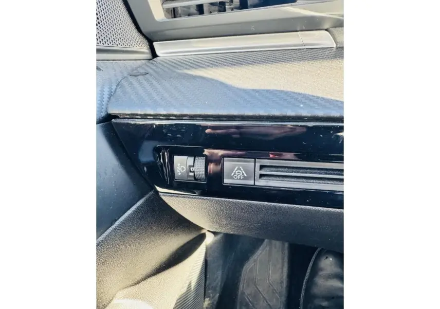 Gros plan sur la console côté conducteur de la Peugeot 508 gris amazonite, avec commandes d’éclairage et ventilation.