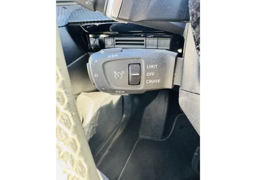 Gros plan sur la commande de régulateur de vitesse au volant d'une Peugeot 508 gris amazonite, intérieur noir.