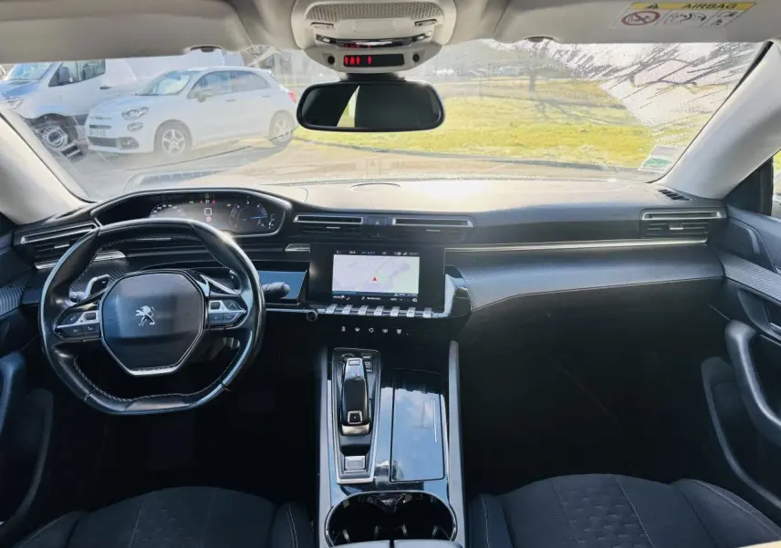Vue intérieure avant du Peugeot 508 gris amazonite, avec tableau de bord numérique et écran tactile central.