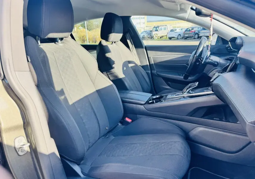 Intérieur de la Peugeot 508 gris amazonite, vue côté gauche sur sièges tissu noir et console centrale moderne.