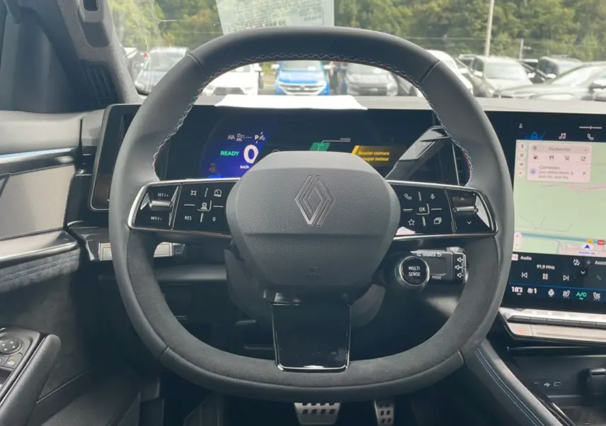 Vue intérieure centrée sur le volant en alcantara du Renault Austral New 200 Esprit Alpine avec tableau de bord numérique et écran tactile.