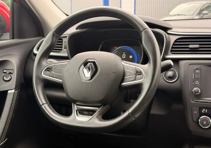 Vue rapprochée du volant en cuir noir d’un Renault Kadjar 2016, avec tableau de bord digital et bouton start/stop visible.