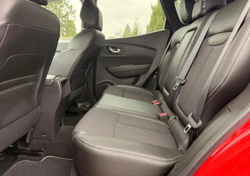 Vue intérieure côté droit des sièges arrière en cuir noir du Renault Kadjar rouge flamme, avec ceinture de sécurité visible.