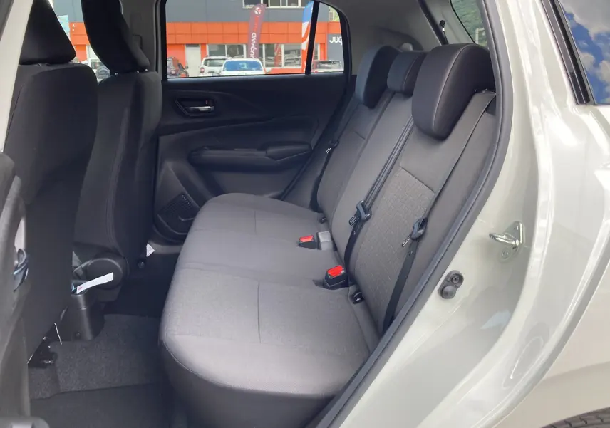Vue intérieure côté droit des sièges arrière en tissu gris d'une Suzuki Swift 2025 blanche, porte arrière ouverte.