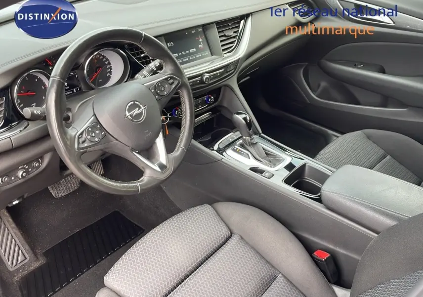 Vue intérieure côté conducteur de l’Opel Insignia Sports Tourer 2021, avec volant multifonction et sellerie tissu gris.