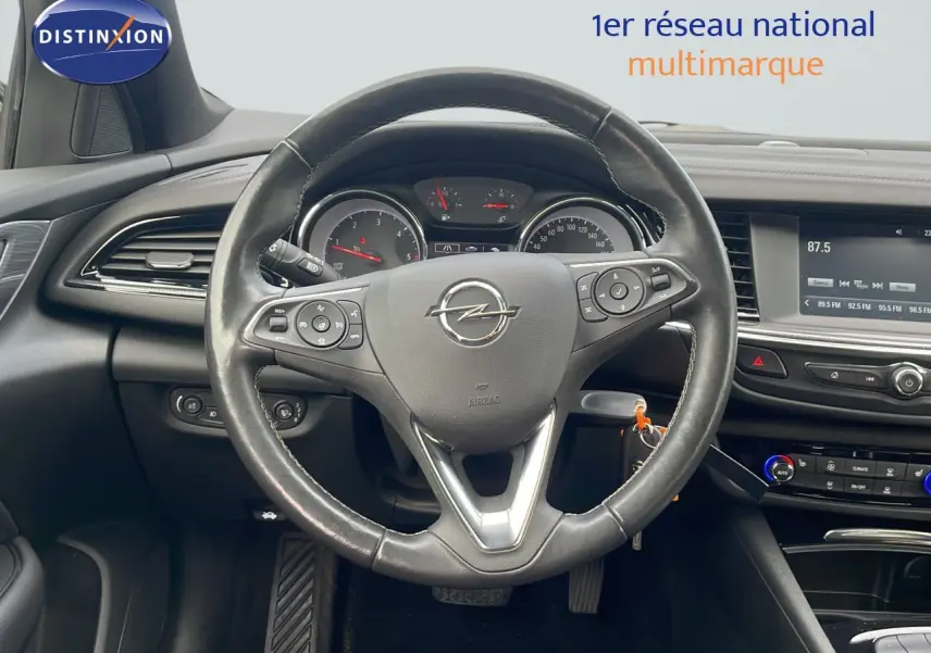 Vue intérieure centrée sur le volant cuir de l'Opel Insignia Sports Tourer 2021, avec tableau de bord et écran multimédia.