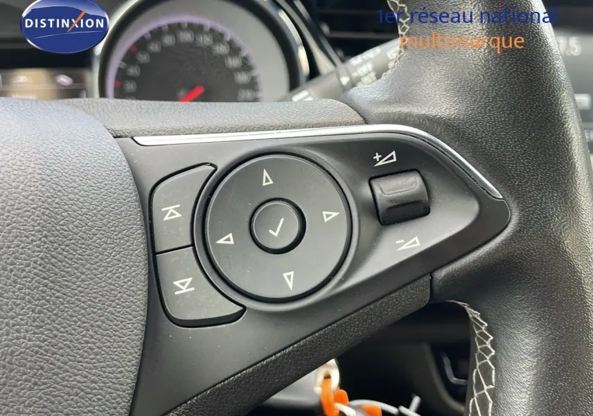 Gros plan sur les commandes du volant noir de l'Opel Insignia Sports Tourer gris acier satinée, modèle 2021.
