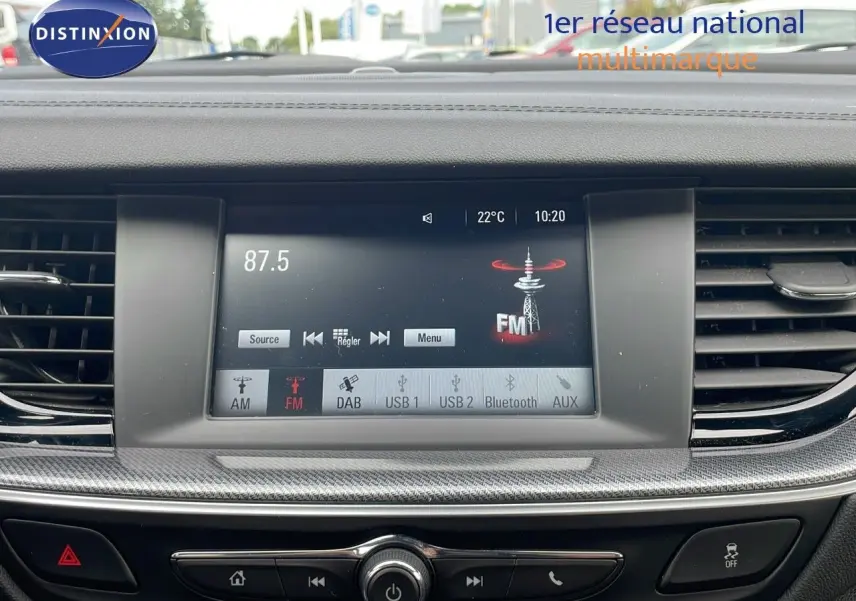 Vue intérieure centrée sur l’écran multimédia de l’Opel Insignia Sports Tourer 2021, affichant la radio FM à 87.5 MHz.