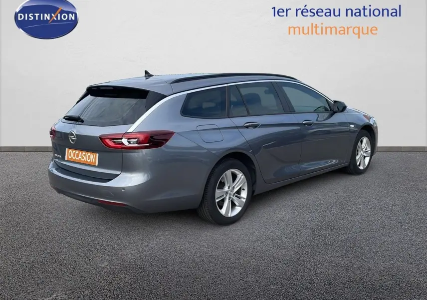Opel Insignia Sports Tourer gris acier satiné vue 3/4 arrière droit, avec jantes alliage et vitres teintées.