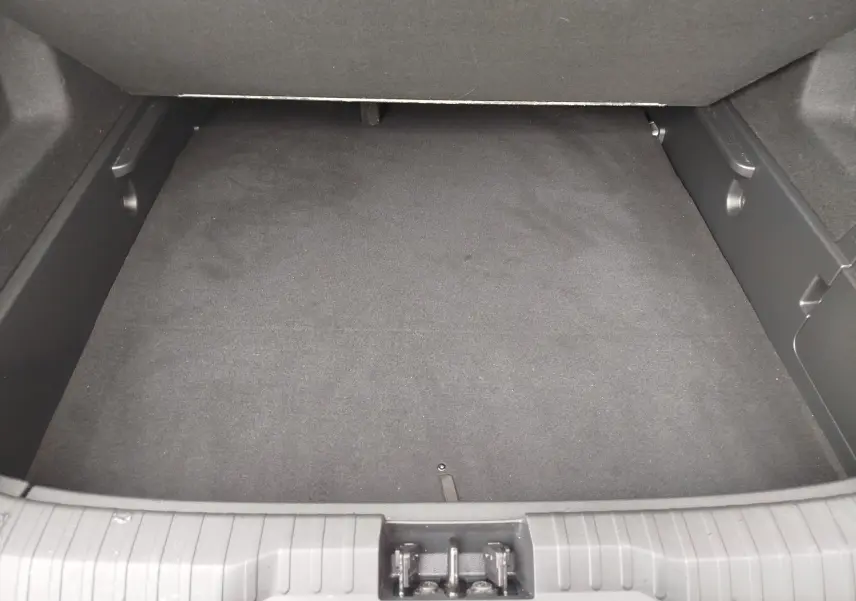 Coffre vide vu de face du Renault Arkana 1.6 E-Tech bleu Zanzibar, intérieur noir avec tapis de sol.