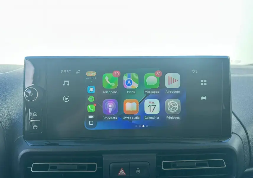 Vue intérieure en gros plan du plafonnier gris clair avec commandes et miroir de courtoisie du Citroën Berlingo blanc.