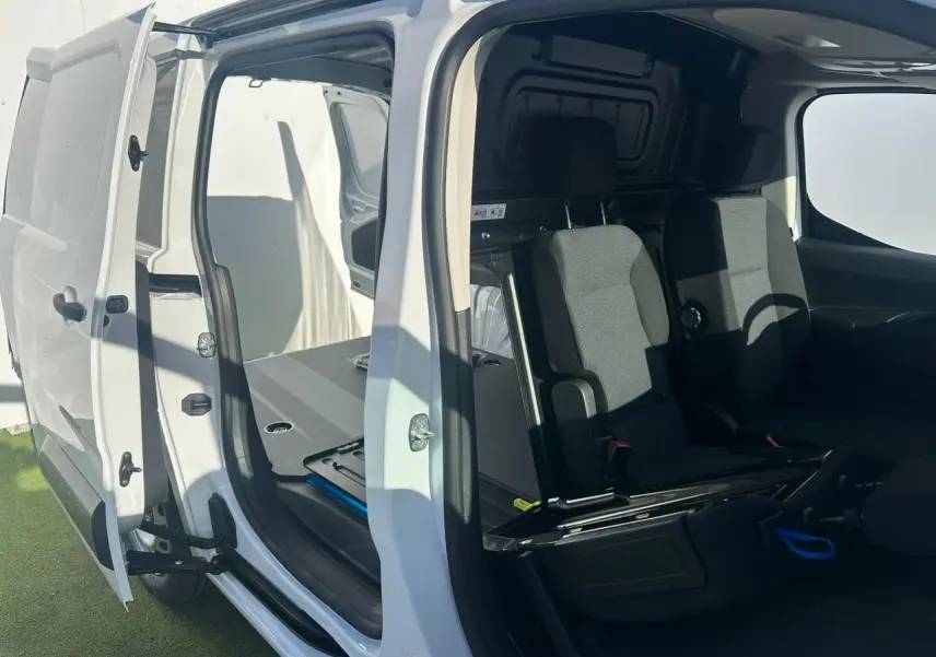 Vue rapprochée de la console centrale noire du Citroën Berlingo blanc, avec commandes climatisation et boîte auto.