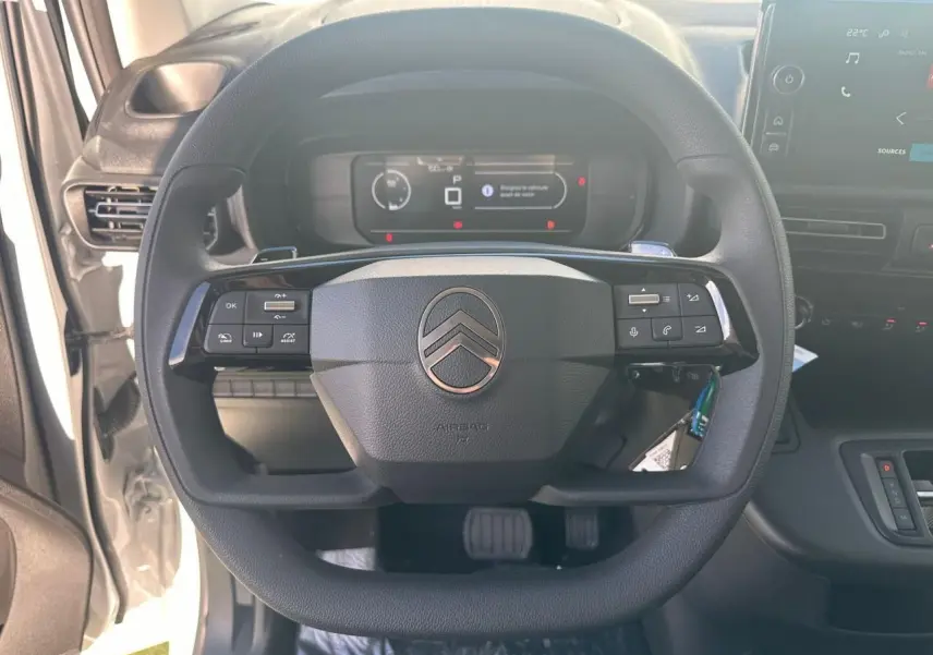 Vue frontale du volant noir du Citroën Berlingo 2026 avec tableau de bord digital et écran tactile à droite.