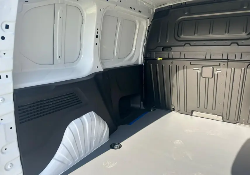 Vue intérieure de la zone de chargement du Citroën Berlingo blanc Icy avec plancher clair et parois noires.