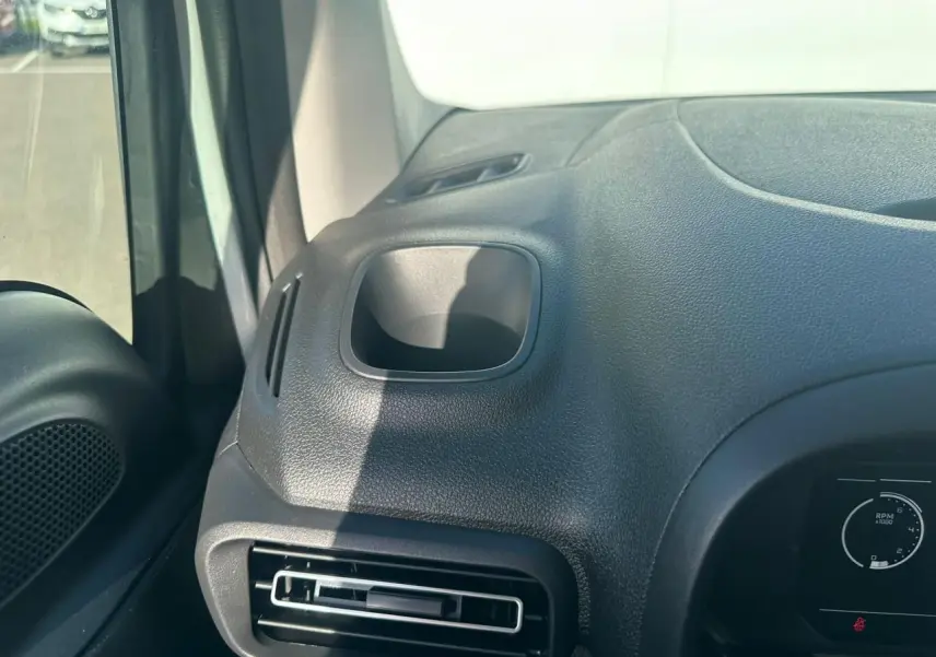 Vue intérieure rapprochée du tableau de bord côté gauche du Citroën Berlingo blanc, avec sortie d'air et rangement intégré.
