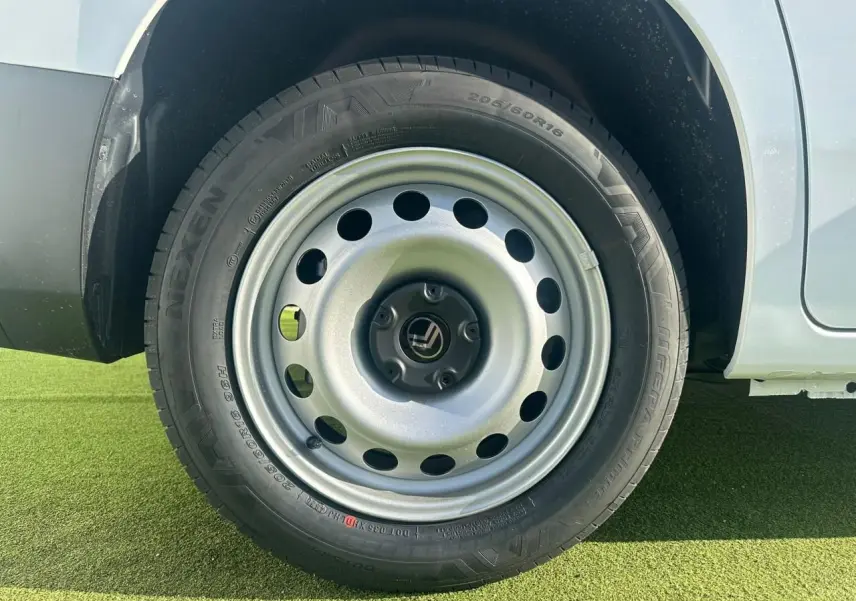 Gros plan sur la roue arrière droite en jante tôle grise du Citroën Berlingo blanc Icy 2026.