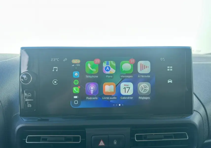 Écran tactile central du Citroën Berlingo blanc, affichant interface Apple CarPlay avec applications et commandes intégrées.