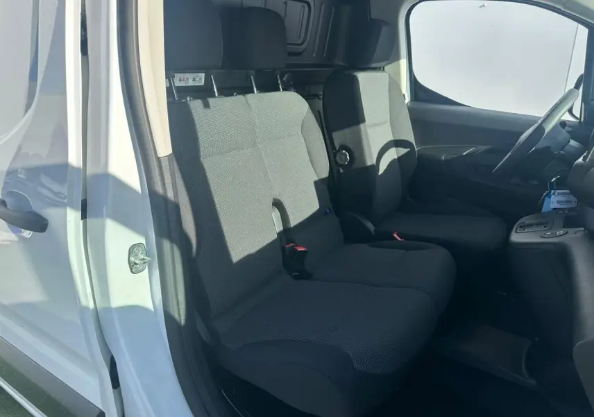 Vue intérieure côté conducteur du Citroën Berlingo blanc Icy, montrant la banquette passager 2 places en tissu gris.