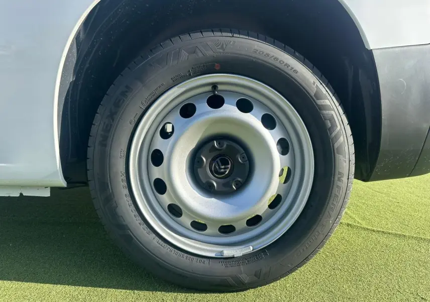 Gros plan sur la roue tôle 16 pouces grise du Citroën Berlingo blanc Icy, côté arrière droit du véhicule.