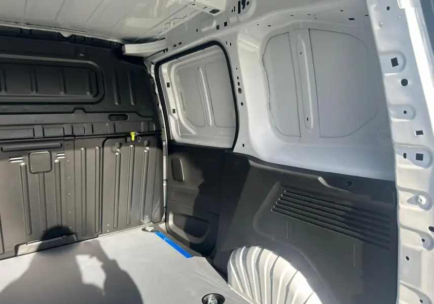 Intérieur arrière du Citroën Berlingo blanc Icy, vue côté droit montrant la zone de chargement et parois tôlées.