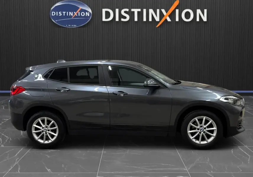 BMW X2 gris minéral métallisé vue de profil côté gauche, avec vitres arrière surteintées et jantes alliage.