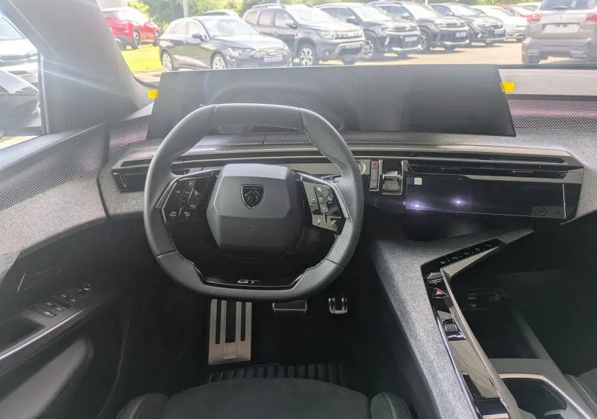 Vue intérieure centrée sur le volant GT et le tableau de bord numérique du Peugeot 3008 Hybrid 2026.