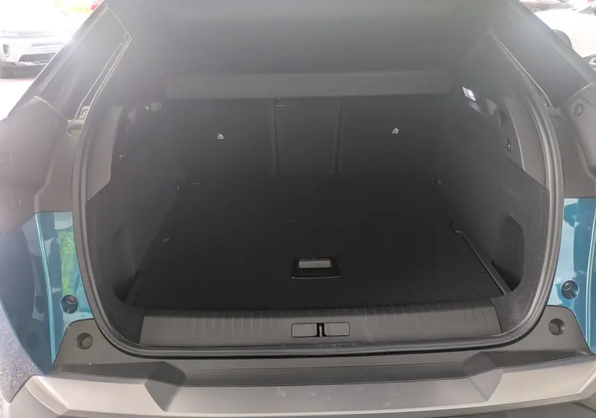 Coffre ouvert vu de l'arrière d'un Peugeot 3008 hybride bleu Obsession avec intérieur noir.