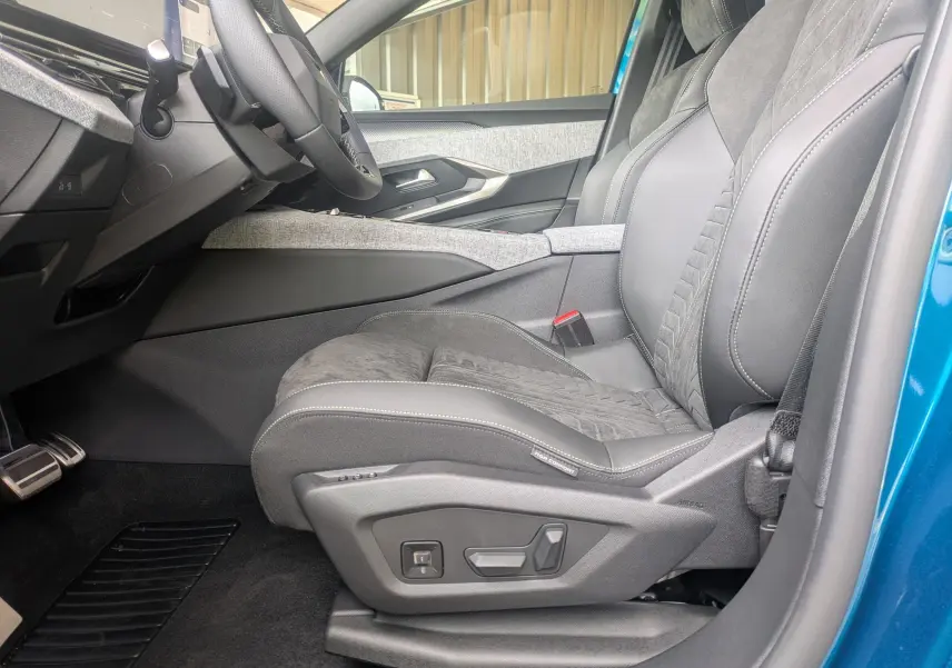Vue intérieure côté conducteur du Peugeot 3008 Hybrid 2026, siège Alcantara noir avec réglages électriques et volant partiel.