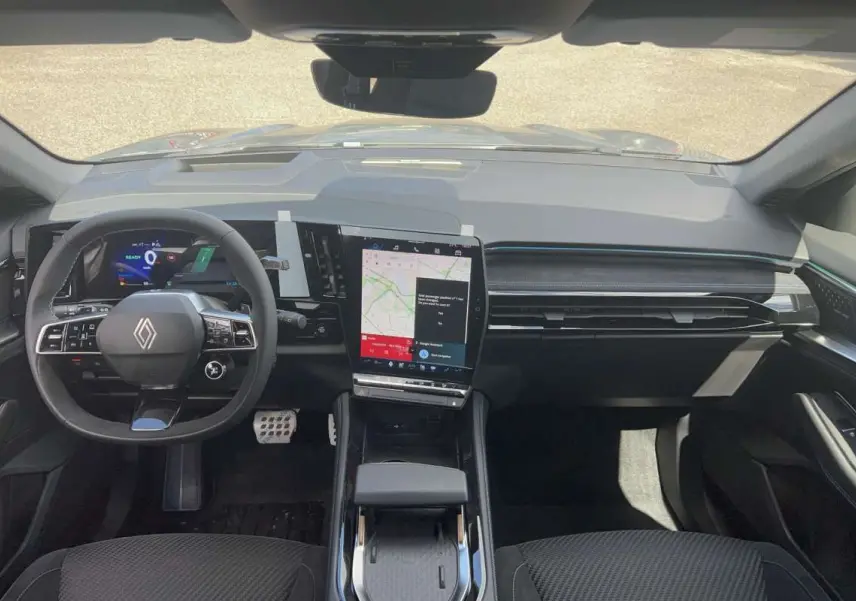 Vue intérieure frontale du tableau de bord du Renault Austral gris schiste, avec écran tactile vertical et volant multifonctions cuir.