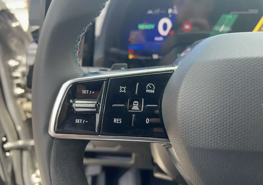 Gros plan sur la partie gauche du volant cuir multifonctions du Renault Austral 200 Esprit Alpine, avec commandes de régulateur.