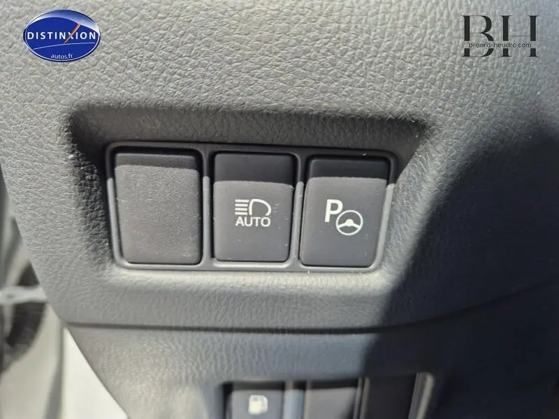 Gros plan sur les boutons de commande d'éclairage automatique et d'aide au stationnement du Toyota C-HR gris aluminium 2019.