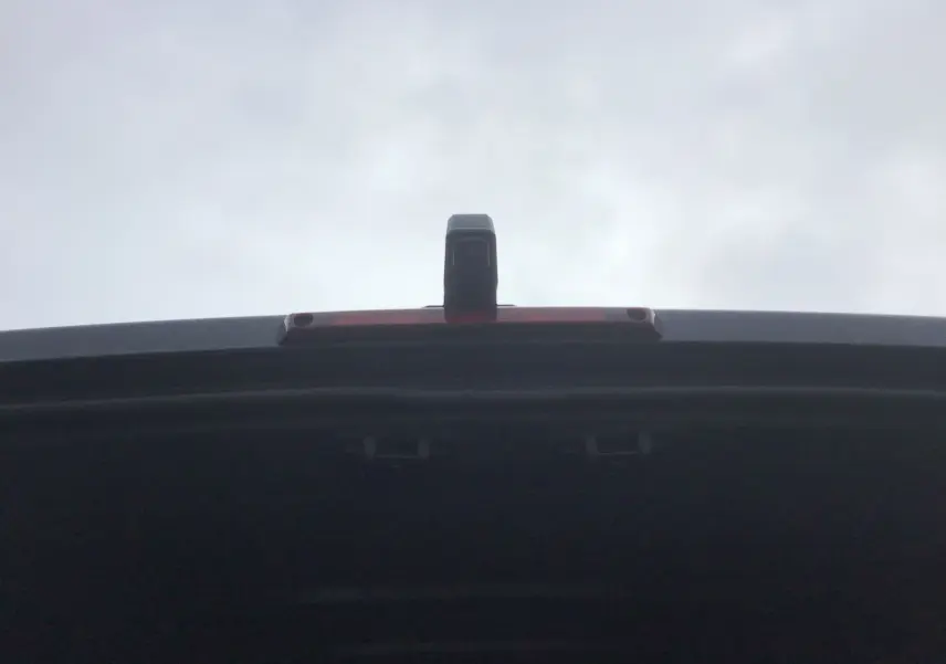 Vue en gros plan sur la caméra de recul installée sur la porte arrière ouverte du Renault Master gris urbain.