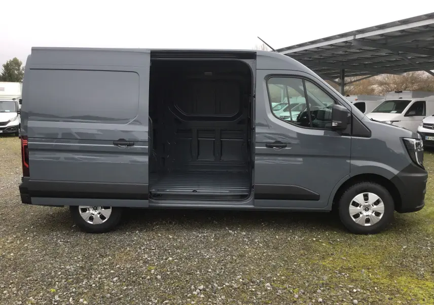 Vue latérale droite d’un Renault Master gris urbain 2025 avec porte coulissante ouverte montrant l’espace de chargement vide.