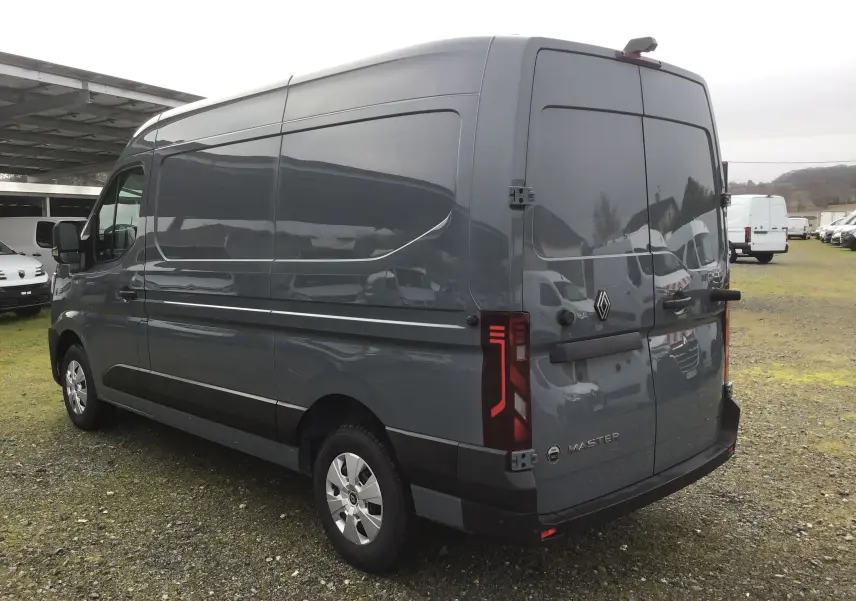Vue 3/4 arrière droite d’un Renault Master gris urbain, fourgon utilitaire avec feux arrière LED et jantes acier.