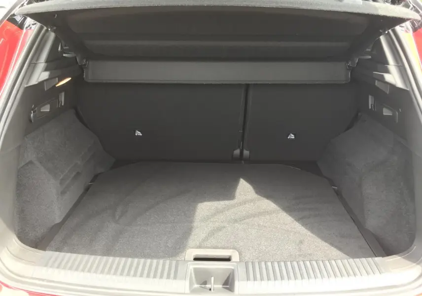 Coffre ouvert vu de l'arrière d'un Renault Austral 2025 rouge et noir, montrant un espace de chargement propre et spacieux.