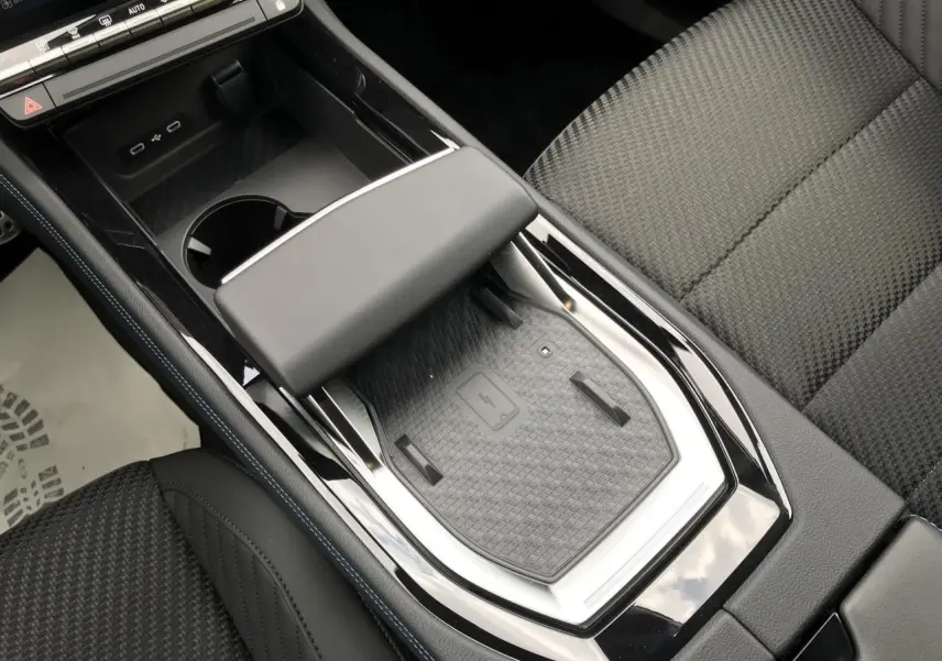 Vue plongeante sur la console centrale noire du Renault Austral 2025 avec chargeur sans fil et accoudoir cuir.