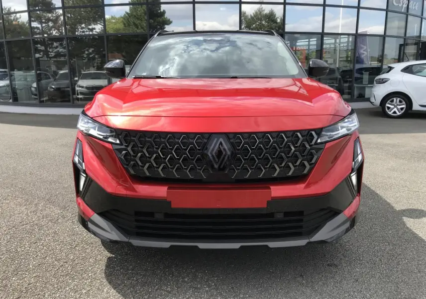 Vue de face du Renault Austral 2025 rouge et noir, mettant en valeur sa calandre hexagonale et ses phares LED fins.