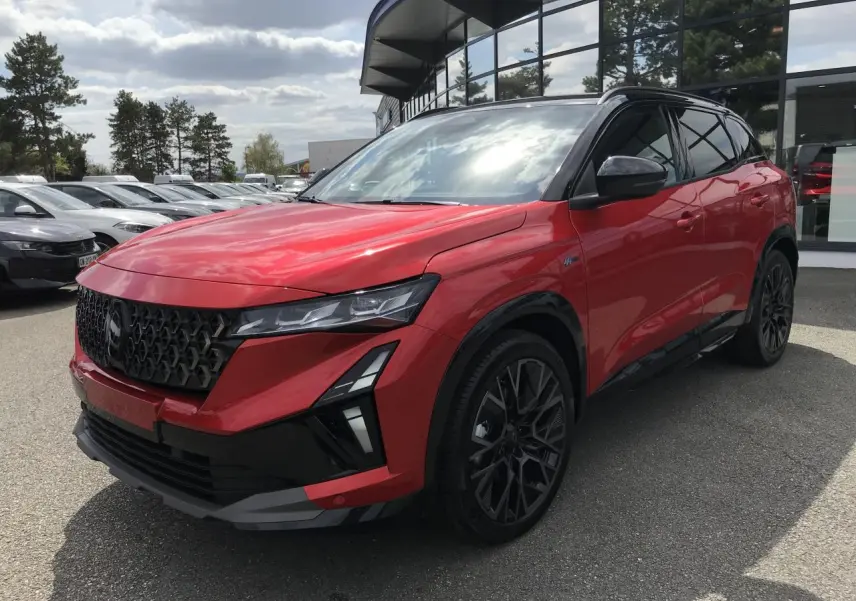 Renault Austral full hybrid rouge et noir en 3/4 avant droit, avec jantes noires et toit bi-ton métallisé.