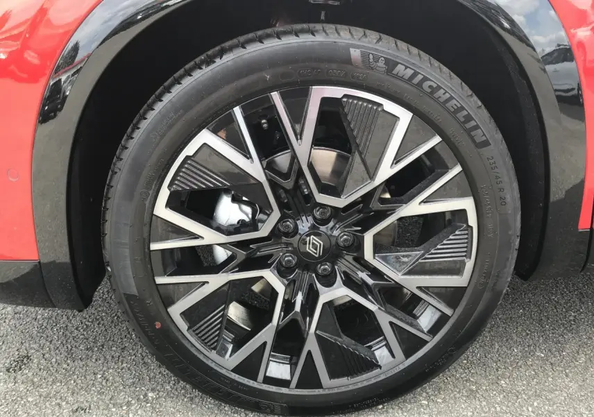 Gros plan sur la jante alliage 20 pouces noir et argent du Renault Austral rouge et noir, côté avant droit.