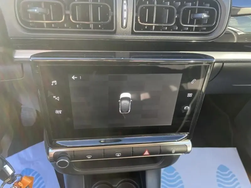 Vue rapprochée de l’écran tactile central et des commandes de la Citroën C3 gris foncé, version 1.2 PureTech 83 CV Feel Pack 2021.
