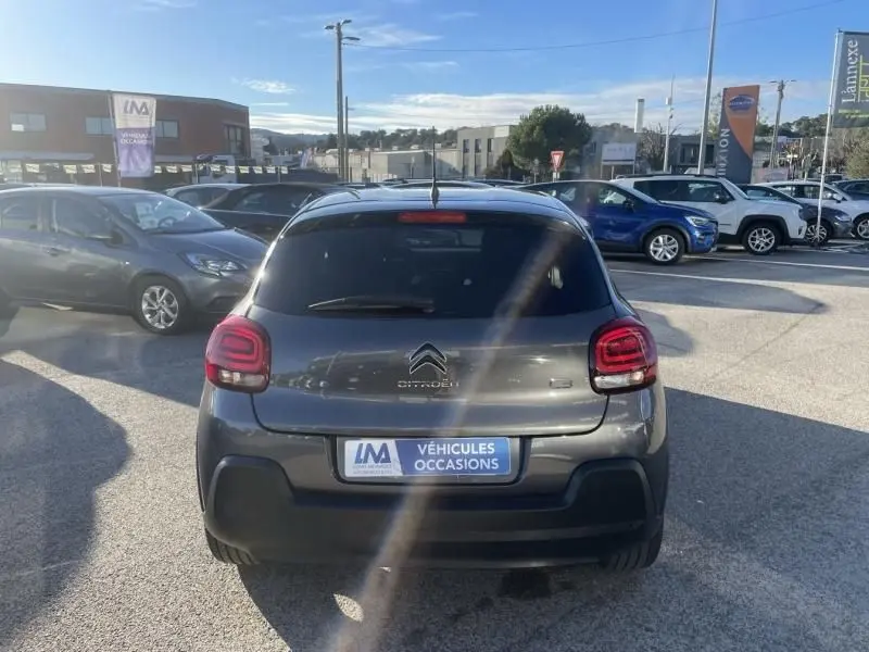 Vue arrière d'une Citroën C3 gris foncé 2021, avec feux arrière distinctifs et plaque d'occasion visible.