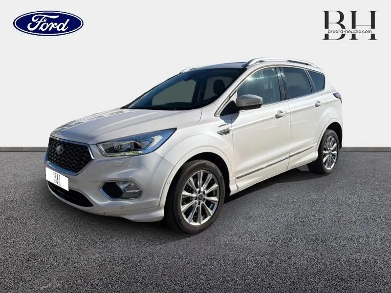 Vue 3/4 avant droite du Ford Kuga blanc Premium Platinum avec jantes alliage et toit panoramique visible.