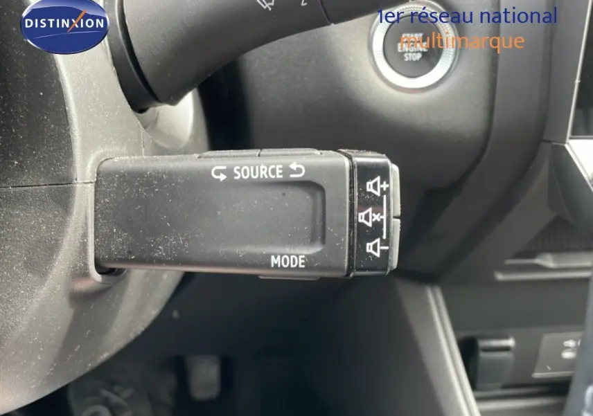 Gros plan sur la commande multimédia au volant du Renault Captur 2025, intérieur gris noir avec bouton start/stop visible.