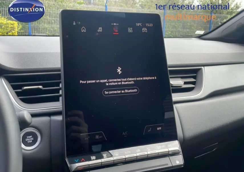 Vue intérieure centrée sur l'écran tactile vertical du tableau de bord du Renault Captur gris cassiopée métal avec toit noir.