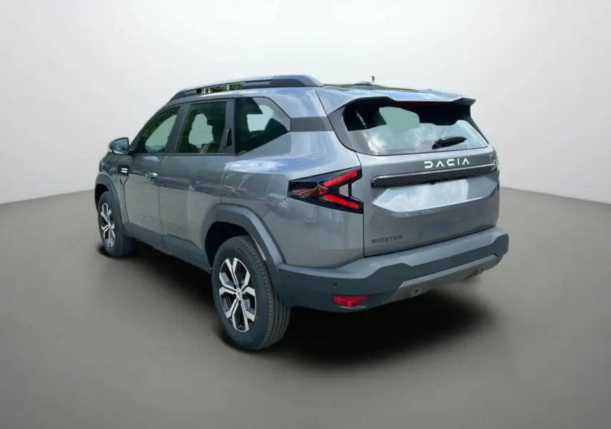 Vue 3/4 arrière droite du SUV Dacia Bigster gris schiste avec barres de toit et jantes alu 17 pouces.