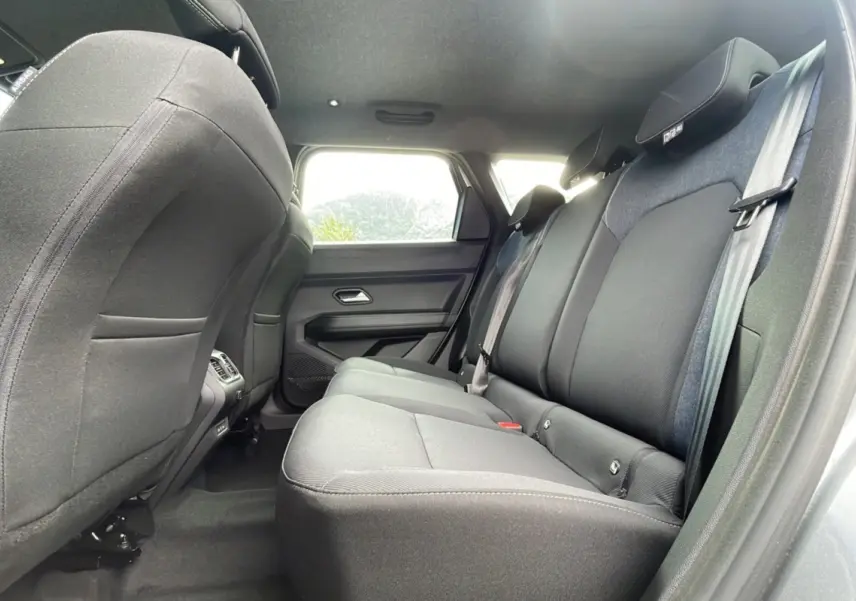 Vue latérale intérieure sur la banquette arrière grise du Dacia Bigster 2025, avec appuie-têtes et ceintures visibles.
