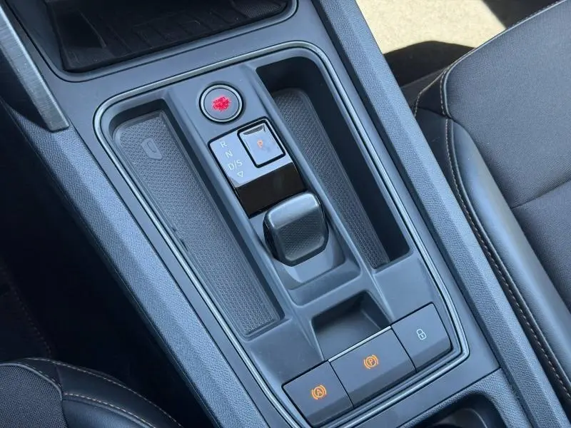 Gros plan sur la console centrale grise du CUPRA Formentor 1.4 e-HYBRID 2024 avec sélecteur de boîte automatique et boutons de frein à main.