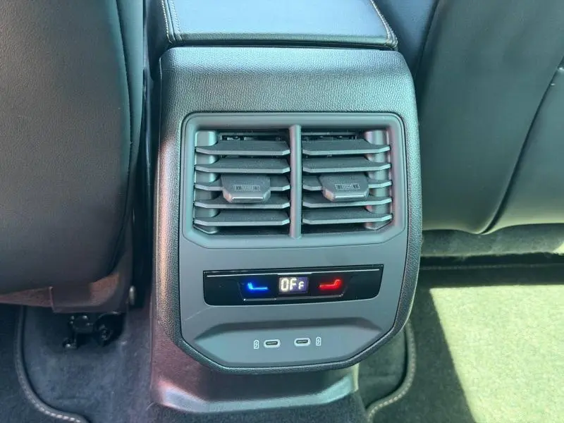 Vue rapprochée de la console arrière noire du CUPRA Formentor 1.4 e-HYBRID avec commandes clim et prises USB.