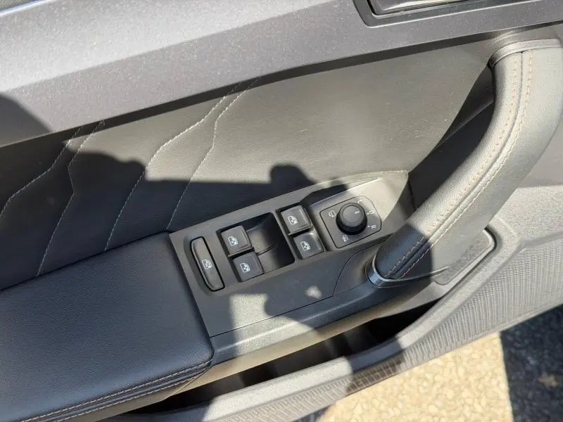 Détail de la porte côté conducteur du CUPRA Formentor gris métallisé, montrant les commandes des vitres et rétroviseurs.