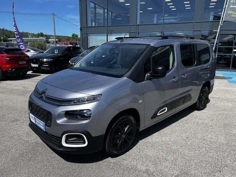 Citroën Berlingo XL gris métal, vue 3/4 avant droit, avec jantes noires et protections latérales distinctives.